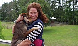 Cokie Berenyi holds her dog on the deck at her home